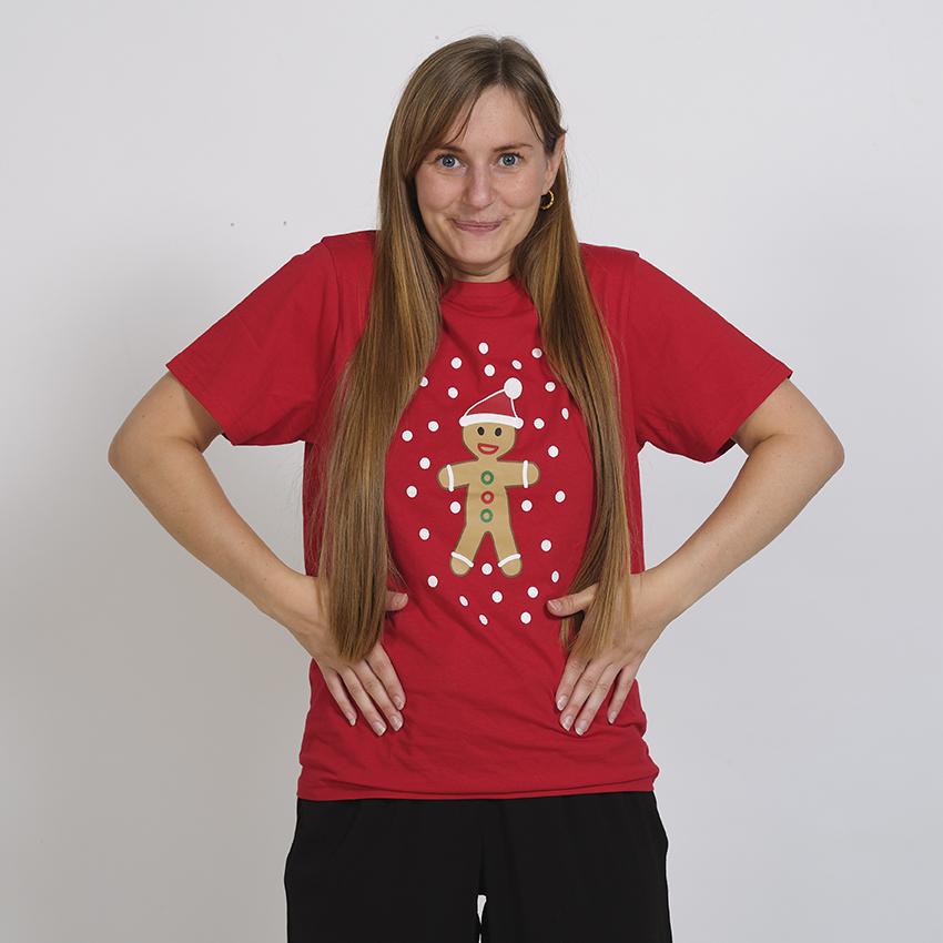 Eine Frau trägt ein rotes T-Shirt mit einem Tortenmann darauf.